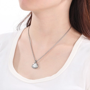 Gros plan d'un collier triangle en argent et nacre avec chaîne torsadée sur un mannequin