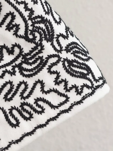 Vue macro détaillée du tissu blanc avec des broderies cachemire noires de haute qualité