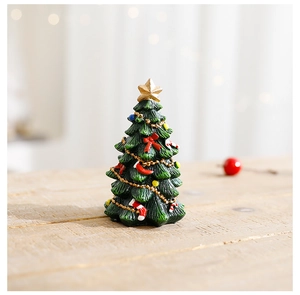 Close-up of a mini resin Christmas tree with colorful ornaments and a golden star topper
