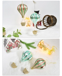 Detail of colorful glass hot air balloon ornaments with glitter accents on snowy texture