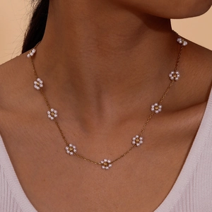 Golden stainless steel cross chain necklace with white pearl flowers and emerald charms