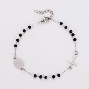 Detail of black beaded rosary bracelet with silver oval medal and cross pendant charms