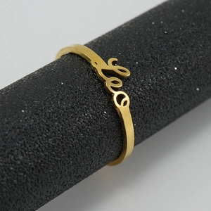 Macro shot of 18K gold Leo zodiac sign ring detailing the elegant script lettering
