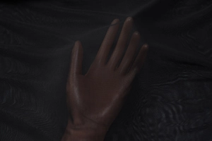 Close-up detail of sheer black mesh fabric showing fine texture and transparency level