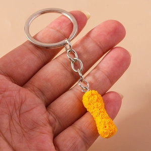 Detailed view of a yellow floral-textured cylindrical keychain with silver hardware