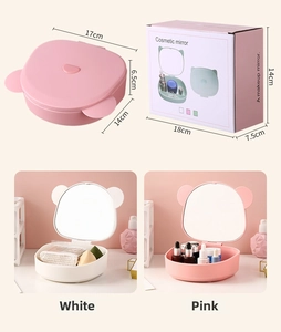 Detail of portable pink and white makeup organizer boxes with animal ears and mirror