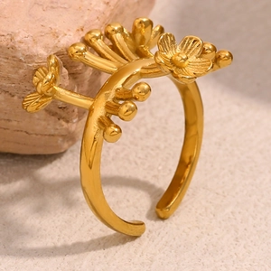 Détail macro d'une bague ouverte fleurie plaquée or 18 carats sur un support rocheux