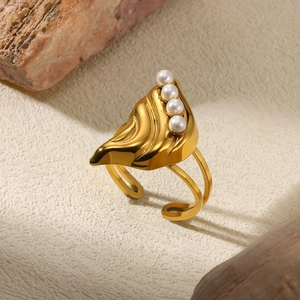 Detailed shot of an adjustable leaf-shaped gold ring featuring four elegant pearls