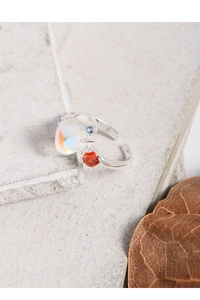Detail shot of heart-shaped moonstone and colorful zircon on a S925 silver open ring