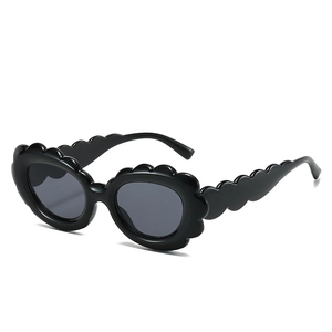 Fashionable black oval sunglasses with stylish wavy scallop edges and dark lenses