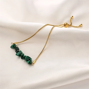 Detail of adjustable gold box chain bracelet with green natural stone beads on silk