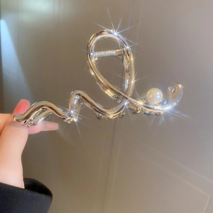 Detailed view of large silver metal wave hair claw clip featuring a white pearl accent