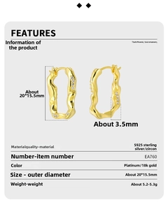 Detail view of irregular U-shaped gold earrings with S925 silver and cubic zirconia specs