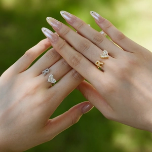 Close-up of gold and silver S925 sterling silver heart and R letter rings on hand