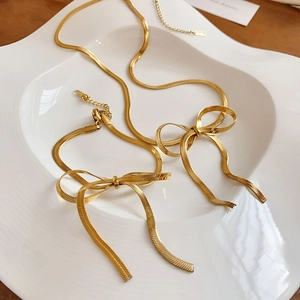 Detailed view of gold butterfly pendant jewelry set with flat snake bone chains
