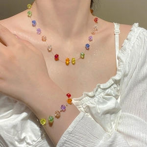Close-up of rainbow acrylic bead necklace and bracelet set on a model in sunlight