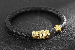 Macro shot of gold skull magnetic clasp on black braided leather gothic bracelet