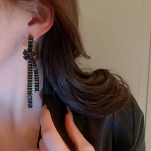 Detailaufnahme schwarzer Zirkon-Knoten-Ohrringe am Modell mit elegantem Glanz