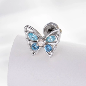 Silver butterfly cartilage earring with blue marquise zircons on white fabric