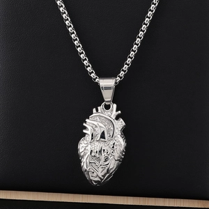 Macro view of anatomical heart pendant in silver titanium steel with beaded chain