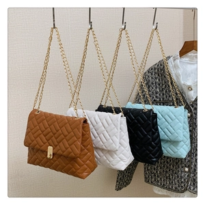 Detailed row of quilted handbags with gold chain straps and rotating square locks