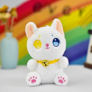 Detail view of a cute white plush cat pendant with heterochromia eyes and a gold bell collar.