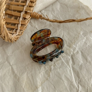 Macro view of a marble pattern acetate hair claw clip with FRANCE Handmade engraving