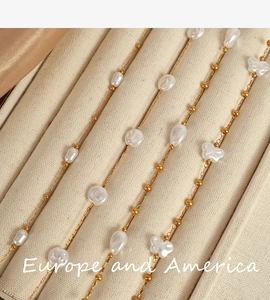 Detailed macro view of baroque pearl necklaces with butterfly charms in 18k gold plating