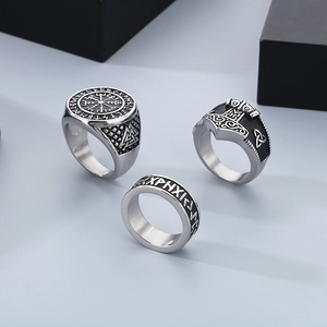 Close-up of Nordic Viking rings featuring Vegvisir compass and runes in aged steel