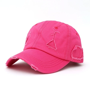 Detail view of pink distressed cotton baseball cap showing frayed edges and vintage texture