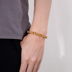 Gros plan d'un bracelet gourmette doré en acier inoxydable avec fermoir tête de mort