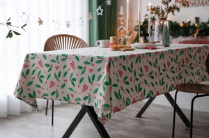 Detail of Christmas tablecloth fabric with red berry and holly leaf patterns
