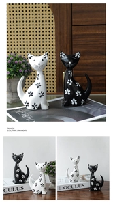 Gros plan de sculptures de chats minimalistes noir et blanc avec détails de fleurs peintes