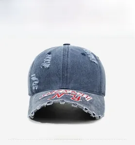 Détail d'une casquette en denim délavé avec broderie NY et bords usés vintage