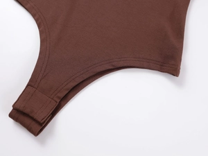 Detail of the snap button closure on chocolate brown cotton knit long sleeve bodysuit