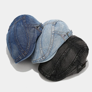 Detailed view of washed denim beret hats showing retro textures and metal buckles