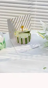 Dettaglio artistico di biglietto d'auguri 3D con torta a strisce verdi e candela