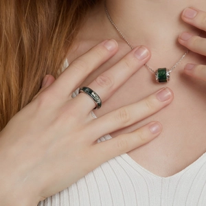 Close-up of woman wearing a silver S925 moss agate ring and matching necklace set