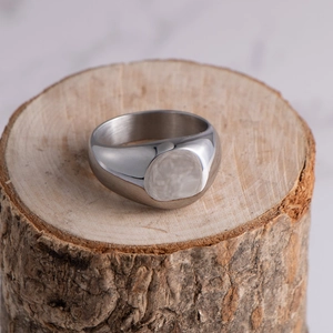 Macro detail of polished silver titanium steel ring on a rustic wooden texture