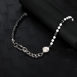 Hip-hop style necklace with black stones, pearls, and a heart pendant on dark texture