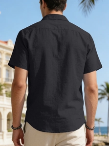 Detail shot of the back of a men's black short sleeve shirt in breathable linen texture