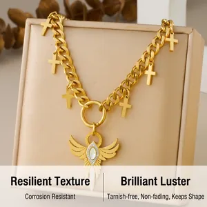 Detailed shot of golden chunky chain necklace featuring cross and angel wing sword pendants