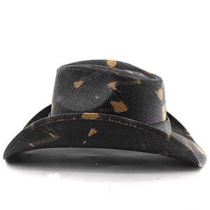 Detail of black woven cowboy hat featuring artistic gold paint splatter and curved brim