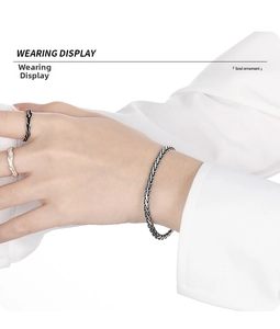 Close-up of S925 sterling silver snake bone chain bracelet and vintage texture rings