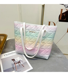 Detail of gradient quilted tote bag with gold logo on a marble surface in 2024 summer style