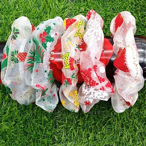 Set of 5 Christmas mesh hair scrunchies with festive prints on a dark bottle display