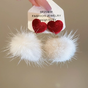 Détail de boucles d'oreilles en argent S925 avec cœur en velours rouge et pompon blanc