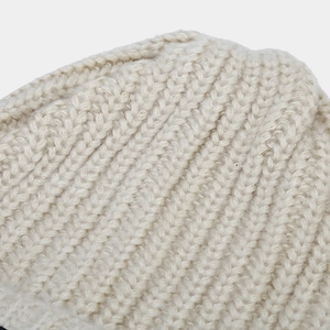 Macro-detail van de beige geribbelde breistructuur en zachte stof van deze muts