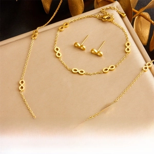 Detail of gold-plated infinity jewelry set featuring necklace, bracelet, and earrings