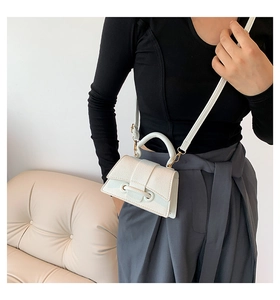 Close-up of white lychee texture leather mini bag with golden hardware and top handle